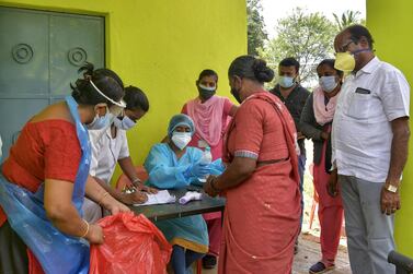 Covid-19 health workers among a community in Bangalore, Karnataka, in India. AFP