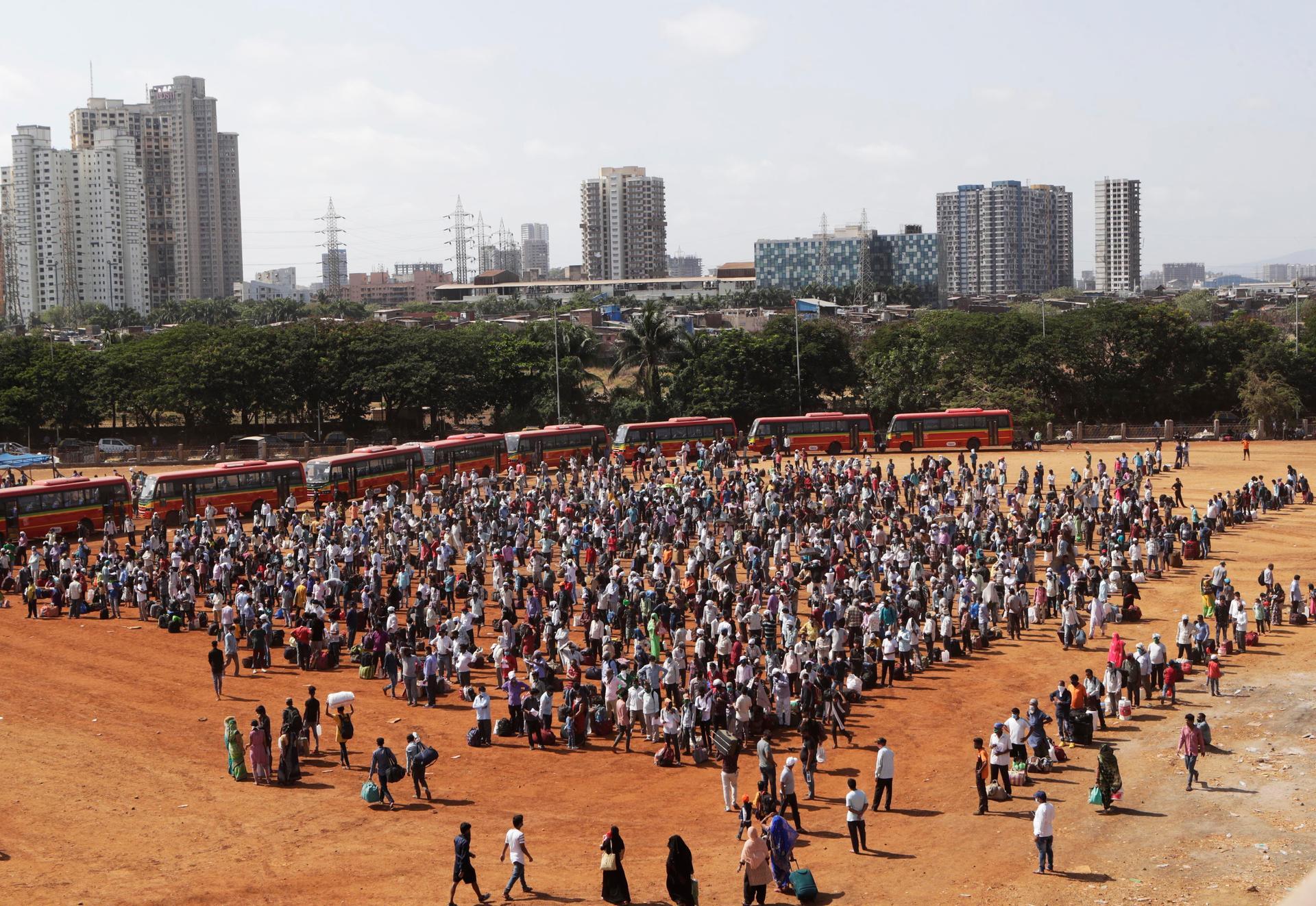 Migrant workers from other states line up to board buses for their onward journey by train to their destination in Mumbai, India. AP Photo