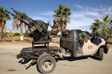 Members of the Libyan National Army loyal to Khalifa Haftar man turrets mounted in the back of pickup trucks as they remain on guard duty. AFP 