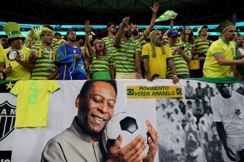 Fans next to a banner of football legend Pele during the World Cup match between Brazil and Cameroon at the Lusail Stadium in Doha, on December 2, 2022. AFP