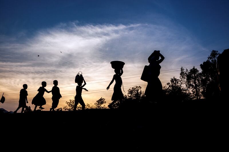 Women and children walk at sunset on a road near Uvira, Democratic Republic of the Congo (DRC), one of the main transit points for Burundian refugees crossing the border. ; Since a political crisis erupted into violence in April 2015, more than 310,000 Burundians have fled the country to Tanzania, Rwanda, Uganda and DRC. Abduction, torture, persecution, threats and extrajudicial killings have instilled fear in many after an attempted coup, aimed at stopping president Pierre Nkurunziza from standing for an unconstitutional third term in office, was suppressed. Over 20,000 Burundians have entered DRC since the crisis began. Most of them are hosted in Lusenda refugee camp but Lusenda and the transit camps at the border are overstretched. UNHCR is working with local authorities to find a suitable location to build another camp to cope with the scale of displacement.