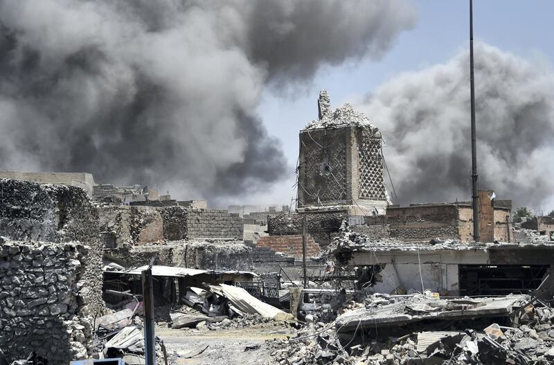 Smoke billows in the background behind the base of Mosul's destroyed ancient leaning minaret, known as the "Hadba" (Hunchback), in the Old City on June 30, 2017, after the area was retaken by the Iraqi forces from Islamic State (IS) group fighters. 
Explosions on June 21 evening levelled the mosque, where Abu Bakr al-Baghdadi gave his first sermon as leader of the Islamic State group and its ancient minaret. - Iraq will declare victory in the eight-month battle to retake second city Mosul from jihadists in the "next few days," a senior commander said on June 30, 2017.
Iraqi forces launched the gruelling battle for Mosul on October 17, 2016, advancing to the city and retaking its eastern side before setting their sights on the smaller but more densely populated west. (Photo by FADEL SENNA / AFP)
