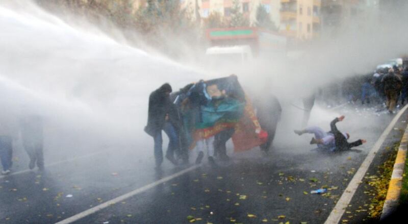 A Kurdish protester falls to the ground as Turkish riot police use water cannons to disperse them during a demonstration in Diyarbakir. Mehmet Engin / AFP Photo