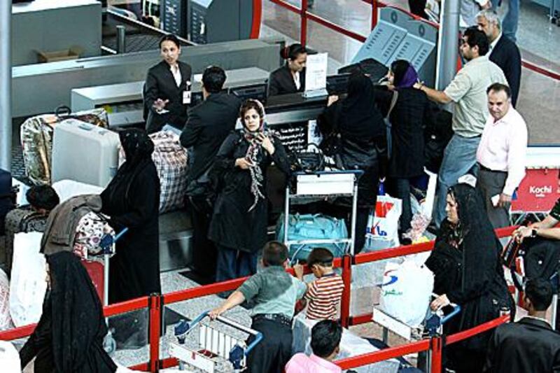 Passengers wait their turn at Sharjah International Airport’s check-in counter.