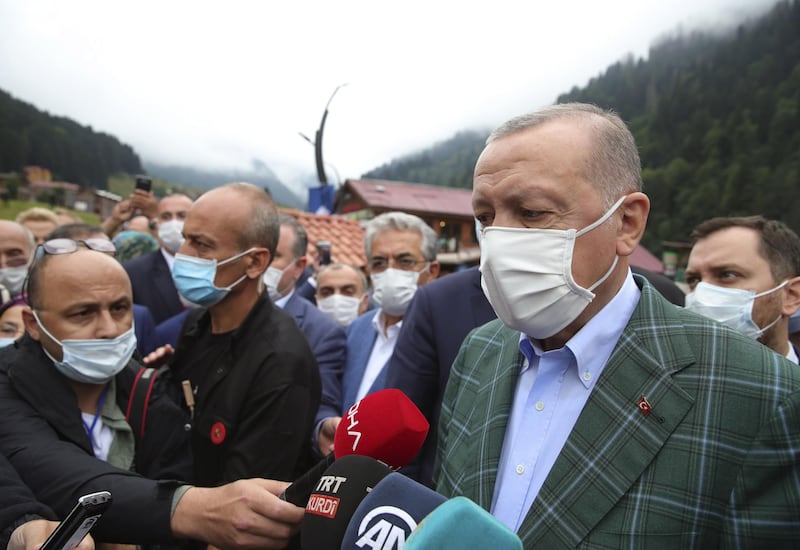 Turkey's President Recep Tayyip Erdogan wearing a face mask to protect against the spread of coronavirus, speaks to the media in Ayder village in the Black Sea city of Rize, Turkey. Turkey's health minister says the number of new COVID-19 infections Saturday has hit its highest in 45 days and announced 1,256 new cases. AP