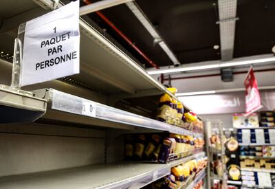 A sign limiting purchases attached to almost empty bread shelves in a Tunis supermarket. AFP