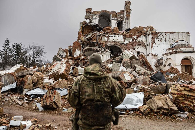 Caesar, 50, a Russian who joined the Freedom of Russia Legion to fight on the side of Ukraine, stands in front of a destroyed monastery in Dolyna. AFP