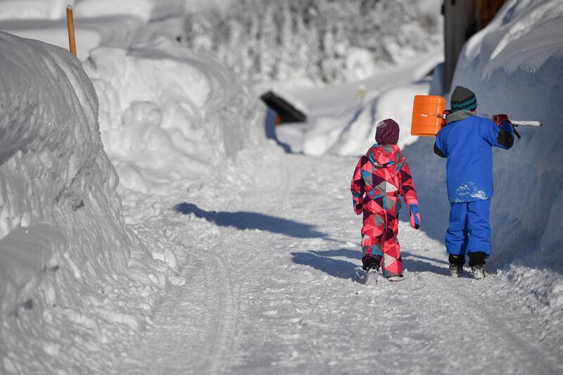 Children walk along a snow covered road in Gerold. EPA