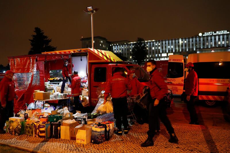 Firefighters organise donated food for ambulance crews waiting long hours to hand over their Covid-19 patients to medics at the Santa Maria hospital in Lisbon. More than 30 ambulances were queueing at a time Thursday evening. Portugal is reporting new daily records of Covid-19 deaths and hospitalisations as a recent pandemic surge continues unabated. AP Photo