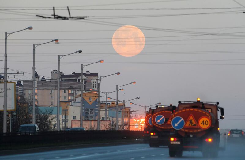 Traffic passes along a road in Minsk, Belarus, as the pink supermoon hangs in the sky. Reuters