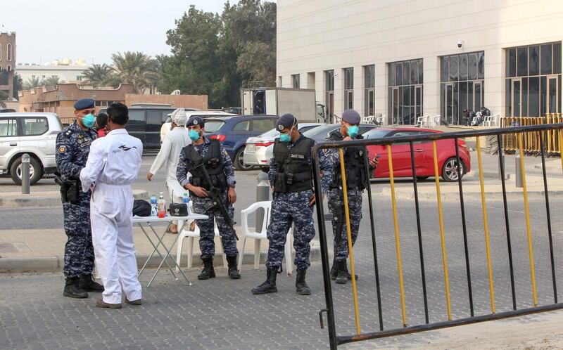 Members of Kuwait's national guard wearing safety masks keep watch outside a hotel in the capital where Kuwaitis returning from Iran are quarantined and tested for coronavirus COVID-19, on February 24, 2020. - Kuwait confirmed three cases who tested positive for coronavirus, a 53-year-old Kuwaiti man, a 61-year-old Saudi citizen, and a 21-year-old stateless Arab (Bidoon), after returning from Iran's holy city of Mashhad. (Photo by Yasser Al-Zayyat / AFP)