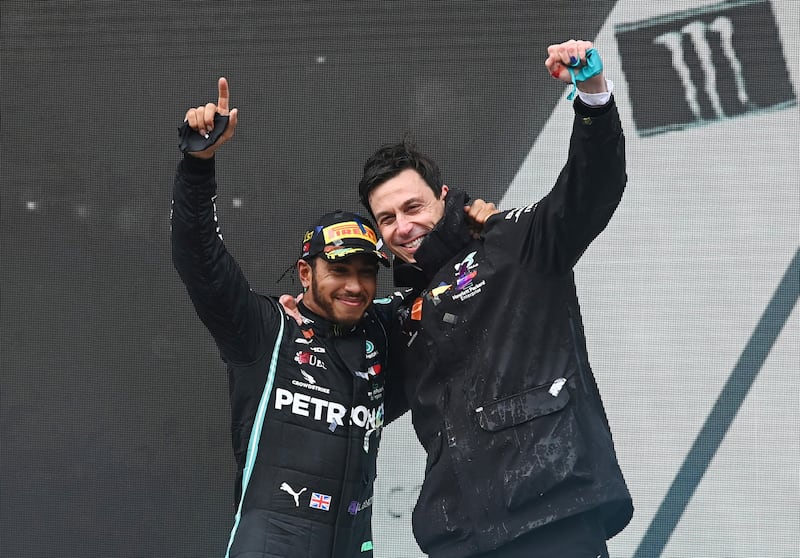Hamilton celebrates on the podium with team principal Toto Wolff after winning the Turkish Grand Prix and the world championship on November 15, 2020. Reuters