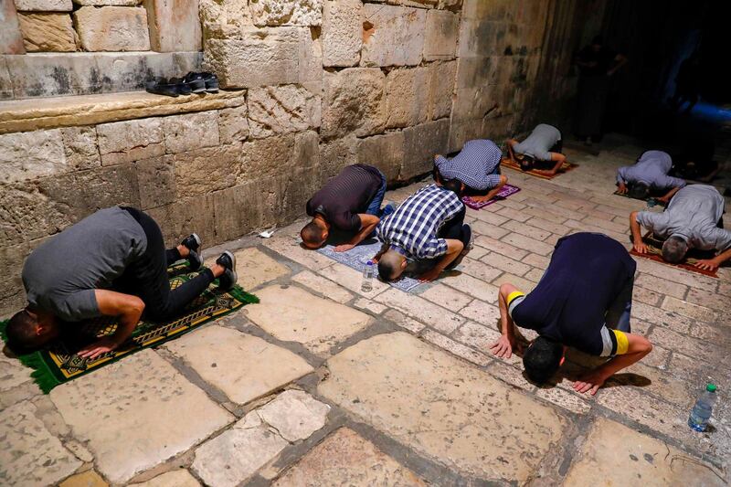 Palestinian Muslim worshippers, distanced from each other due to the Covid-19 pandemic, pray outside the closed Al Aqsa Mosque compound in the Old City of Jerusalem, as they mark Lailat Al Qadr, one of the holiest nights during Ramadan.  AFP
