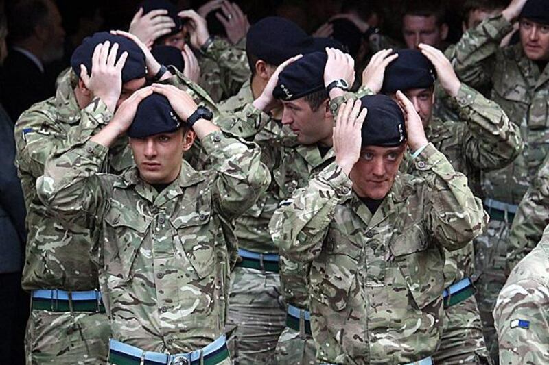 BATH, ENGLAND - NOVEMBER 23:  Soldiers adjust their berets as they leave a thanksgiving service at Bath Abbey before they parade around the city and receive the Freedom of Bath on November 23, 2011 in Bath, England. The troops from 21 Signal Regiment (Air Support) have just returned from a six-month tour of duty in Afghanistan, proving vital communications networks across Helmand. (Photo by Matt Cardy/Getty Images)