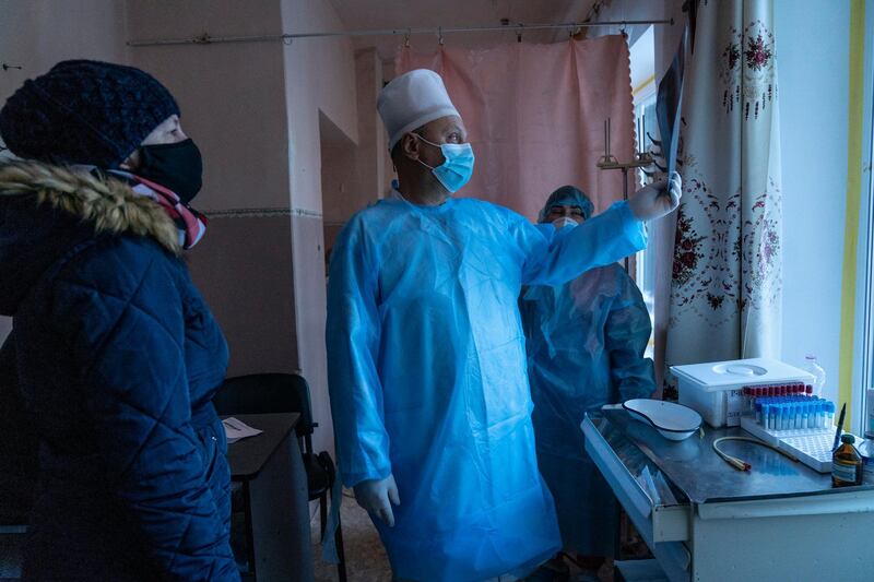 A doctor looks at the X-rays of a patient's lungs at the central hospital in Kolomyia, western Ukraine. AP