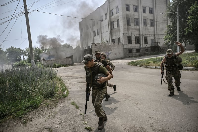 Ukrainian soldiers run for cover during clashes with Russian troops in Lysychansk. AFP