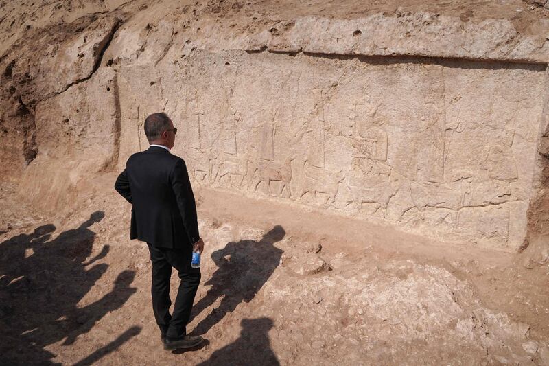 Mr Greganti looks at one of the carved plaques, which measure five metres wide and two metres tall.