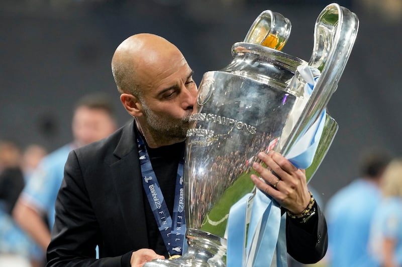 Manchester City's head coach Pep Guardiola kisses the trophy after winning the Champions League final soccer match between Manchester City and Inter Milan. AP