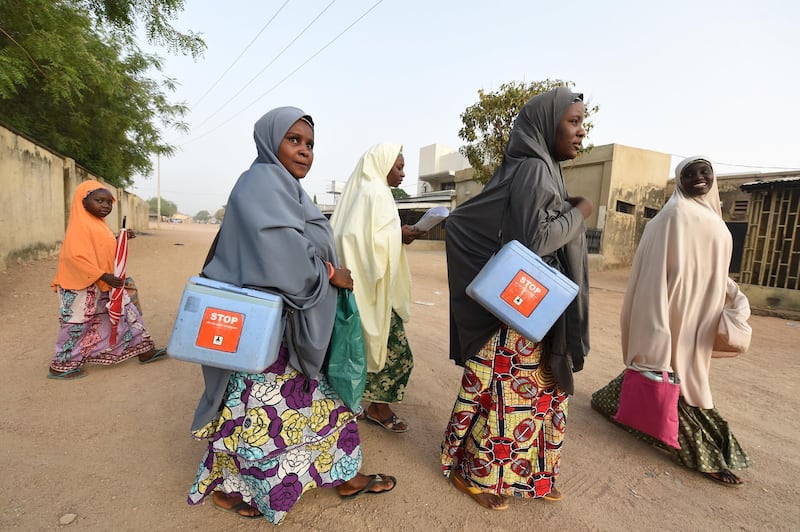 Health workers walk from house to house in search of children to immunise during vaccination campaign against polio at Hotoro-Kudu, Nassarawa district of Kano in northwest Nigeria, on April 22, 2017. - The World Health Organization said 116 million children are to receive polio vaccines in 13 countries in west and central Africa as part of efforts to eradicate the disease on the continent. "The synchronised vaccination campaign, one of the largest of its kind ever implemented in Africa, is part of urgent measures to permanently stop polio on the continent," the WHO said. (Photo by PIUS UTOMI EKPEI / AFP)