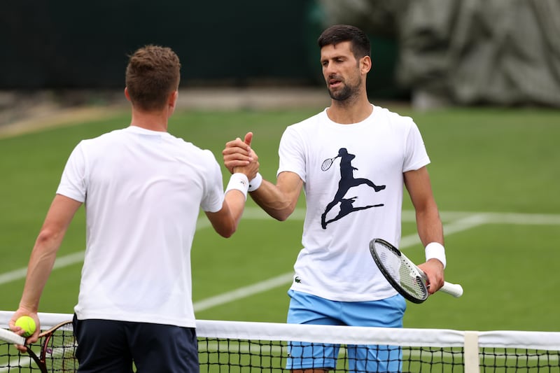 Novak Djokovic shakes hands with Jiri Lehecka during practice. Getty