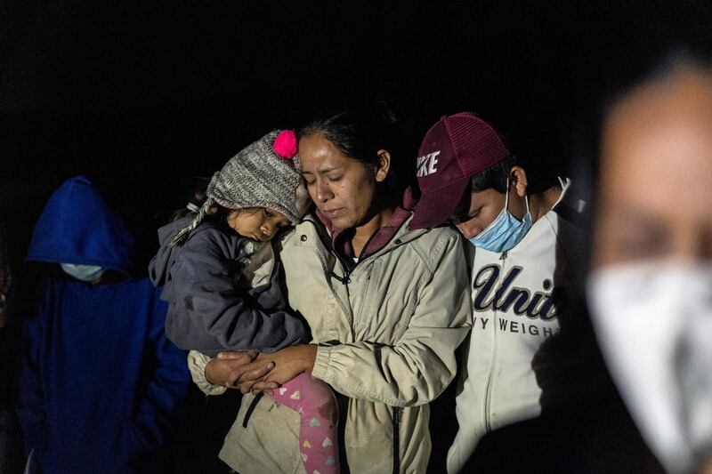 Migrant families pray after crossing the Rio Grande into the US from Mexico, in Roma, Texas, April 20. Reuters