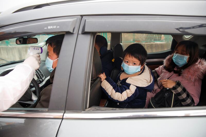 A medical worker checks the body temperature of a driver at a checkpoint outside the city of Yueyang, Hunan province, near the border with Hubei province, which is in lockdown. Reuters