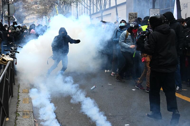 A protester, surrounded by tear gas, gestures during a demonstration for 'social rights' and against the 'global security' draft law.  AFP