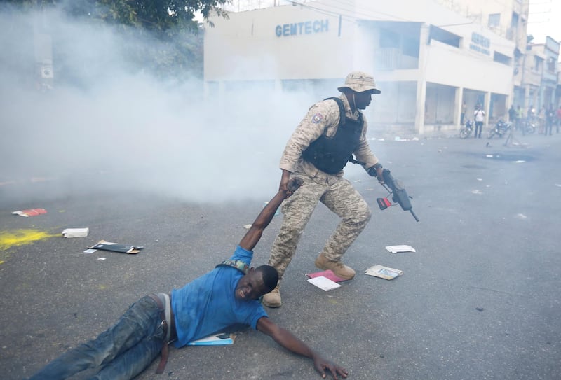 A police officers detains a man on suspicion of looting during anti-government protests. Reuters