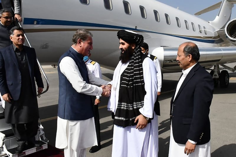 Afghanistan's acting foreign minister Amir Khan Muttaqi, second right, welcomes Pakistan Foreign Minister Shah Mahmood Qureshi at Kabul airport on October 21, 2021. AFP