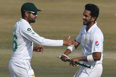 TOPSHOT - Pakistan's captain Babar Azam (L) celebrates with teammate Hasan Ali after winning the Test series against South Africa during the fifth and final day of the second Test cricket match between Pakistan and South Africa at the Rawalpindi Cricket Stadium in Rawalpindi on February 8, 2021. / AFP / Aamir QURESHI