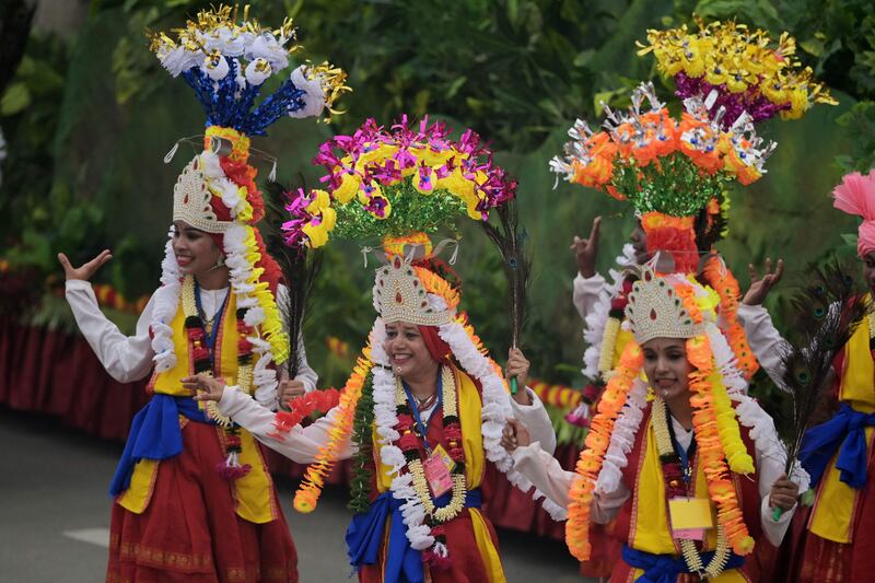 Women in traditional clothes perform. AFP