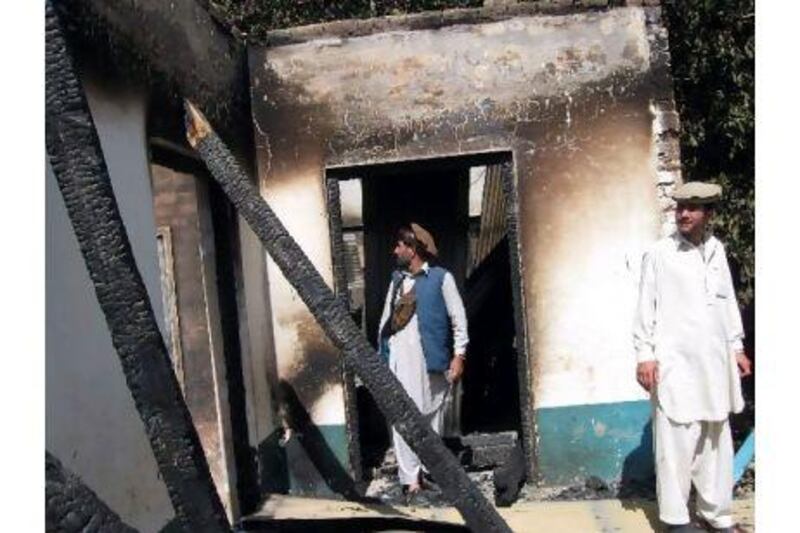 Tribesmen inspect a burnt-out school after an attack by Taliban in the northwestern district of Upper Dir on June 3, about six kilometres from the border with Afghanistan.