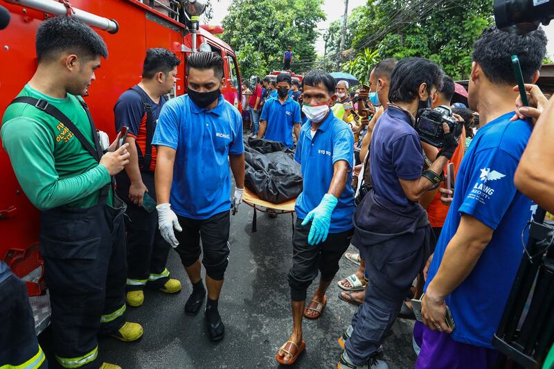 Funeral workers carry victims' bodies.