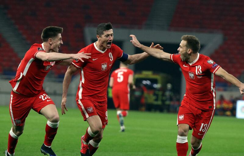 Poland's forward Robert Lewandowski celebrates scoring with his team-mates during the FIFA World Cup Qatar 2022 qualification football match Hungary v Poland at the Puskas Arena in Budapest on March 25, 2021.
 / AFP / Peter Kohalmi
