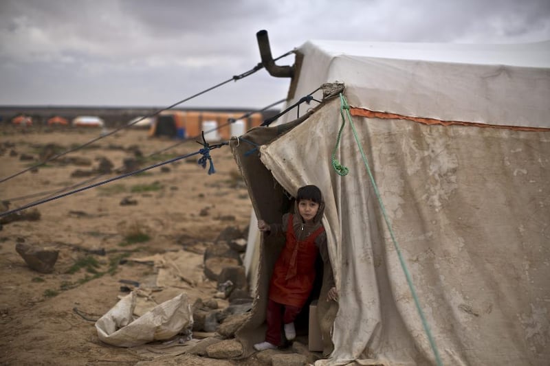 Ayshah Ibrahim, 6, and her family are preparing for the winter storm to hit the tent camp at Mafraq in Jordan.  Muhammed Muheisen / AP Photo