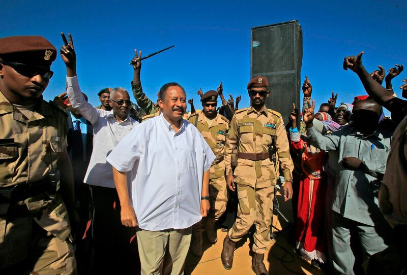 Sudan's Prime Minister Abdalla Hamdok (C) is greeted by supporters upon arriving in El-Fasher, the capital of the North Darfur state. Hamdok's one-day visit was his first as prime minister to the devastated region, where a conflict that erupted in 2003 has left hundreds of thousands dead and millions displaced. He said his government was working toward bringing peace to war-torn Darfur as he met hundreds of victims of the conflict who demanded swift justice. AFP