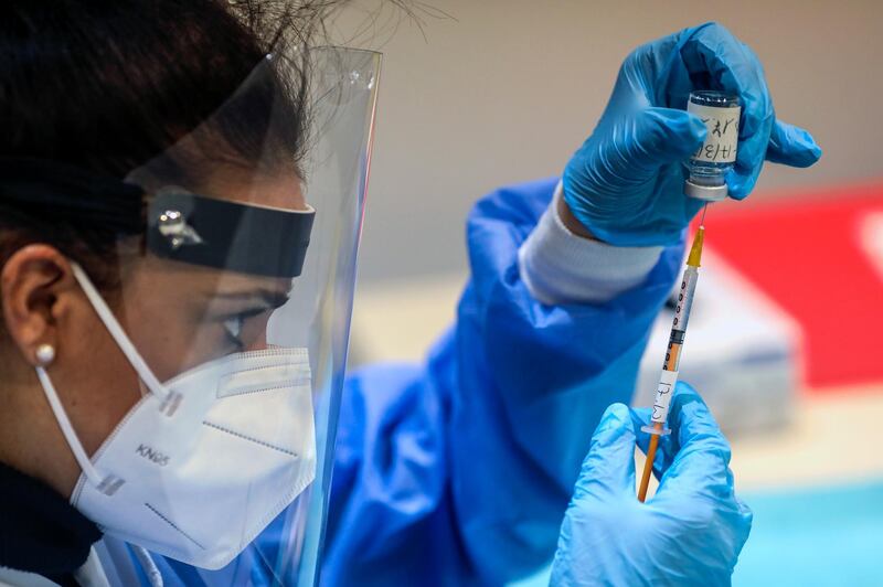 A health worker draws doses from a vial of the Moderna Covid-19 vaccine in Rome, Italy. Bloomberg