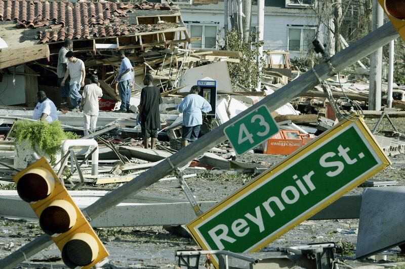 Residents inspect damage left by Hurricane Katrina 30 August 2005, in Biloxi, Mississippi. At least 80 people were feared dead along the coast of the southern state of Mississippi, where glitzy casinos, plush homes and shrimp fishing businesses lay in ruins, after a storm surge up to 30 feet (10 metres) high crashed ashore on Monday. Helpless authorities in New Orleans meanwhile watched as surging floodwaters gushed through a 200 feet (600 meter) hole in the 17th Street Canal defences, indundating a low-lying city already 80 percent under water. AFP PHOTO/Robert SULLIVAN (Photo by ROBERT SULLIVAN / AFP)