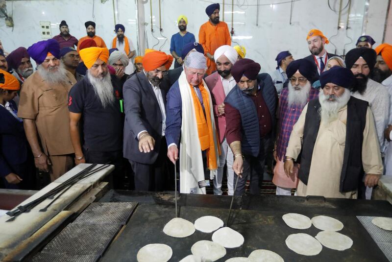 Prince Charles prepares bread at a community kitchen during his visit to a Gurudwara. Reuters