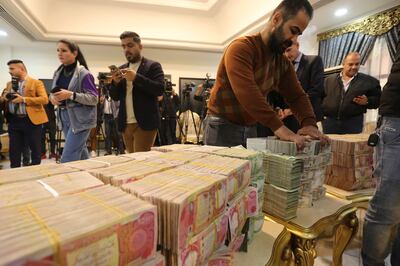 Officials lay out blocks of banknotes ahead of a press conference by the head of the Federal Authority of Integrity in Baghdad. AFP