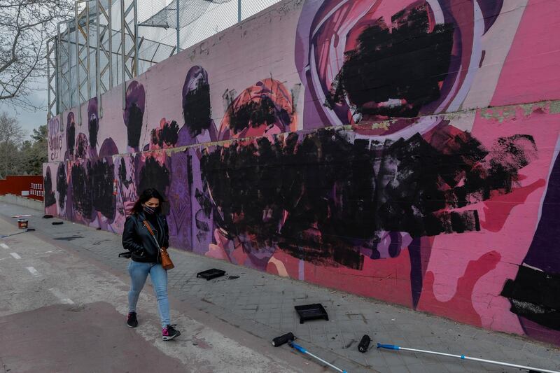 A woman walks past a feminist mural vandalised on International Women's Day in Madrid, Spain. The original mural celebrated pioneering women, such as Rosa Parks, Frida Khalo, Angela Davis and Valentina Tereshkova, among others. AP Photo