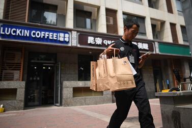 A deliveryman leaves a Luckin Coffee in Beijing. Firm says it aims to outgun in Starbucks on in China. AFP 