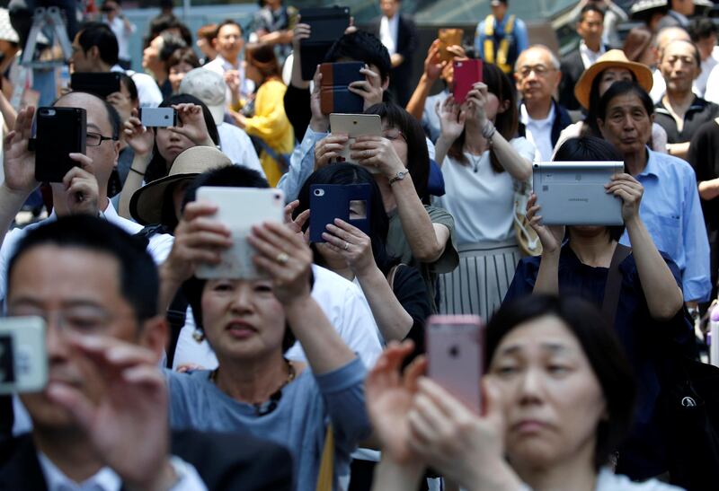 Voters using smart phones take photos of Tokyo governor and head of Tokyo Citizens First party Yuriko Koike (not in picture) as she delivers a speech to voters as election campaign officially kicks off for Tokyo Metropolitan Assembly election, on the street in Tokyo in June. Issei Kato / Reuters