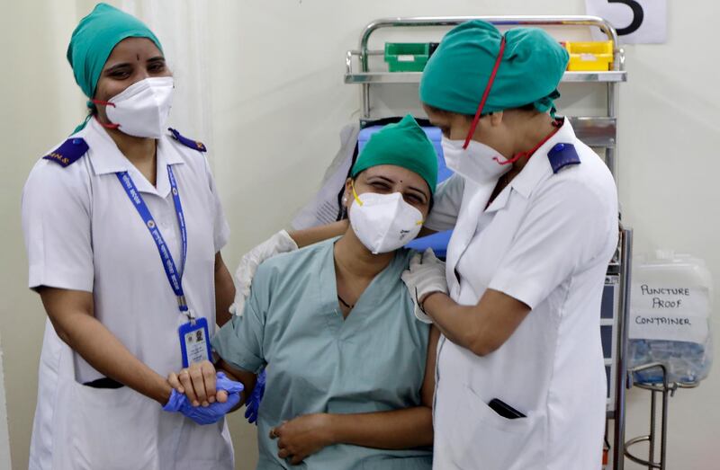 A health worker reacts after receiving a dose of Covaxin vaccine at a vaccination centre in Mumbai, India. AP Photo