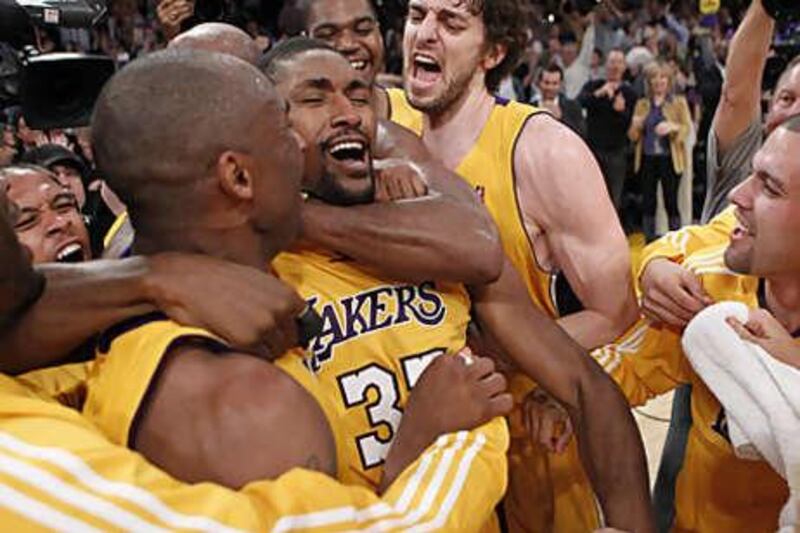 Ron Artest, second from left, is mobbed by his Lakers teammates after his last-second game-winner against Phoenix.
