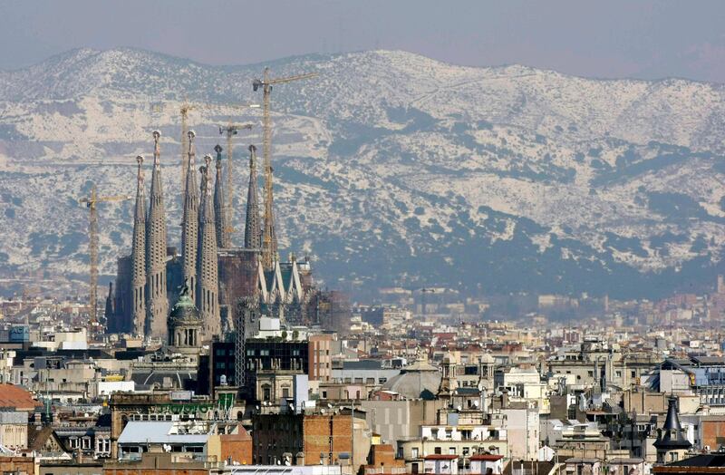 Gaudi's Sagrada Familia and Barcelona's skyline are seen against the backdrop of a snow-covered mount after a snowstorm March 9, 2010.  REUTERS/ Albert Gea (SPAIN - Tags: ENVIRONMENT CITYSCAPE) *** Local Caption ***  BAR103_SPAIN-_0309_11.JPG