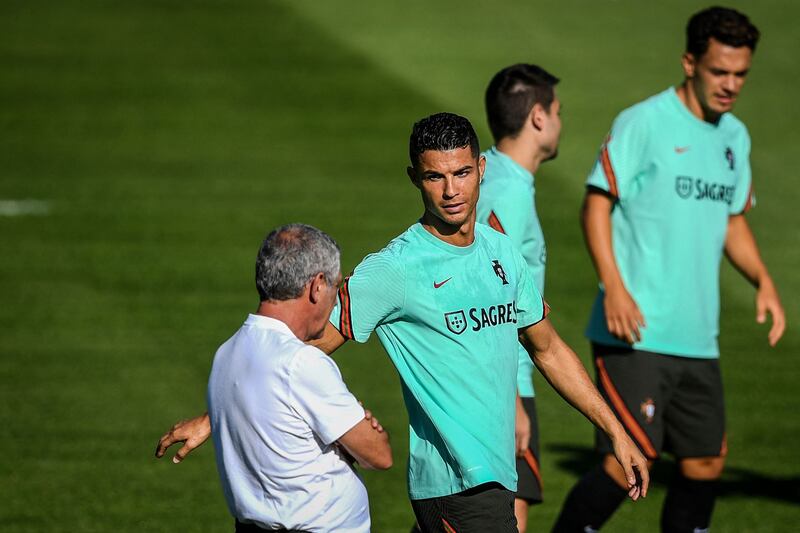 Cristiano Ronaldo speaks with manager Fernando Santos at training. AFP