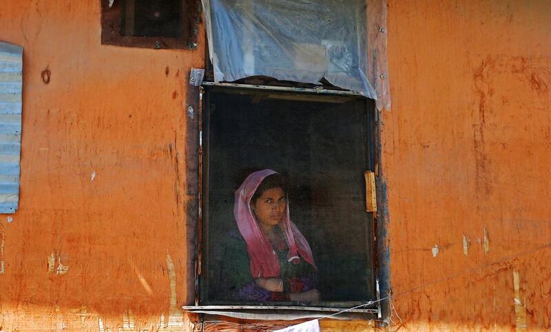 A woman looks out from a window during a protest against the recent killings in Kashmir, in Srinagar, India, on September 16, 2016. Danish Ismail / Reuters