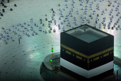 Pilgrims pray in front of the Kaaba, while maintaining social distance, at the start of this year's Hajj.  