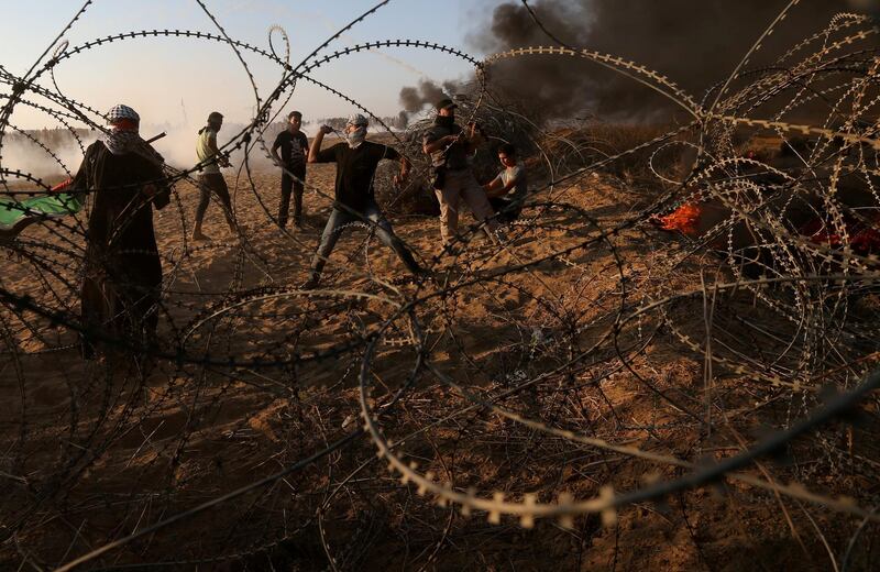 Palestinians hurl stones at Israeli troops during the protest. Reuters